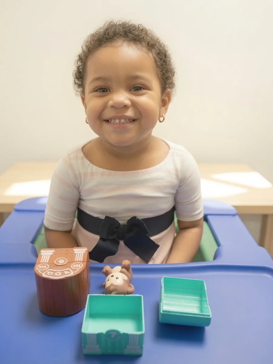 Smiling toddler during a play-based bilingual speech therapy activity